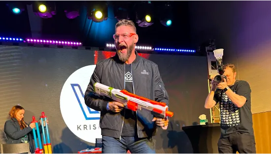 Speaker holding a nerf gun at a conference